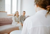 Une personne est assise en face de deux personnes