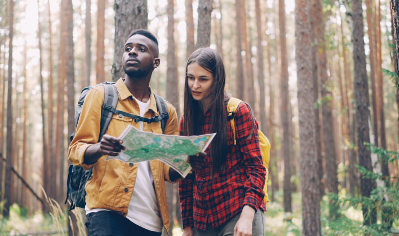 Découverte Deux personnes en forêt regardent une carte