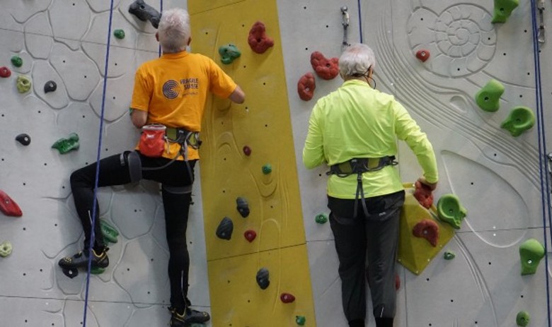 Kurse Zwei Männer klettern an der Kletterwand
